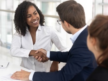 A man and woman in suits shaking hands. 