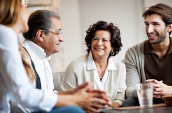 Four people talking around a table. 