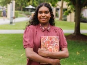 A First Nations person holding a book.