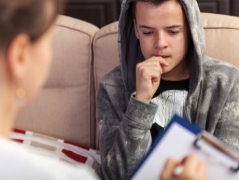 A person listening to a young person speak about their experiences. 