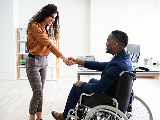 An employer shaking hands with a person with disability.