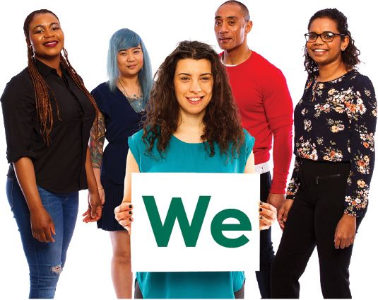 A group of people. The person at the front is holding a card that reads 'We'.