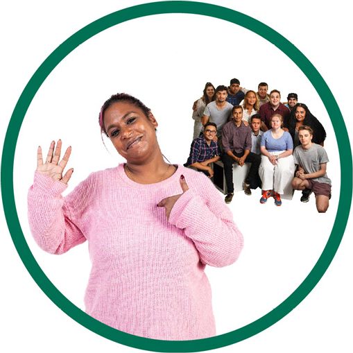 A person with disability pointing to themself with their other hand raised. Behind them is a diverse community of people.