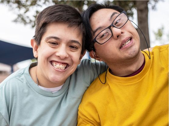 A pair of friends with disability posing for a photo.