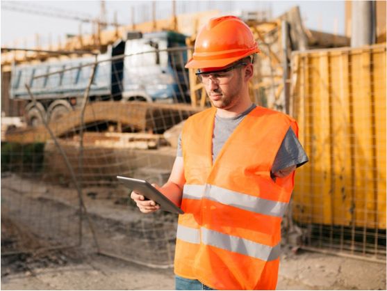 A person with disability wearing high visibility clothes and safety equipment working on a construction site.