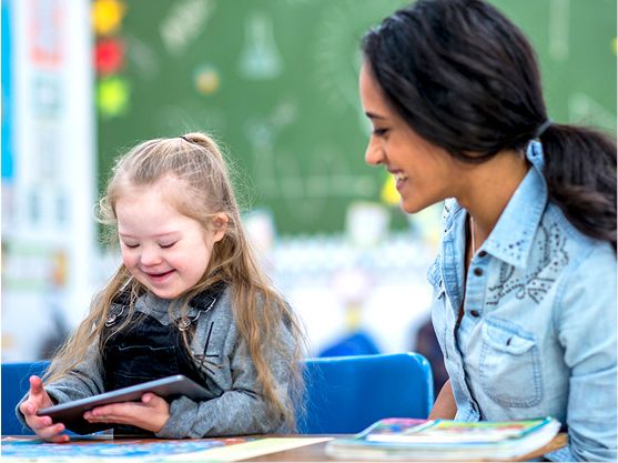 A teacher supporting a student to read.