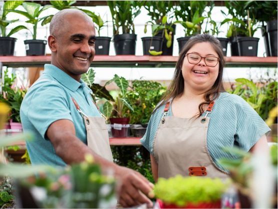 An employer working with a person with disability in a garden store.