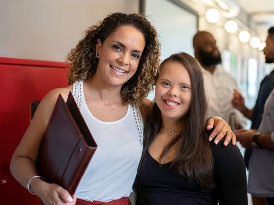 A person with disability posing for a photo with their employer.