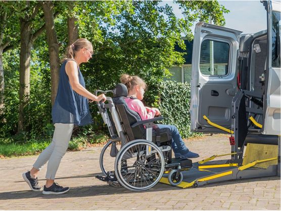 A person with disability being supported to access transport.