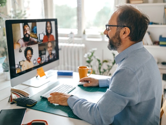 A person on a computer in a Microsoft Teams meeting with 4 other people. 