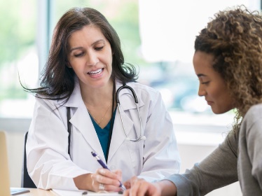 A doctor writing on a document.