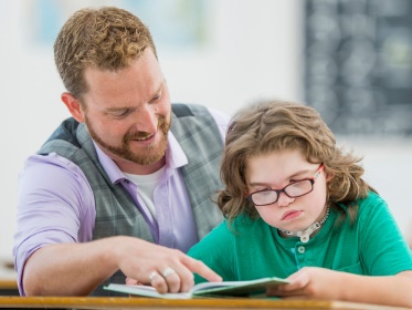 A teacher supporting a child.