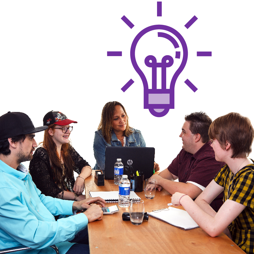 A group of people sharing ideas around a table, with a lightbulb icon above them.