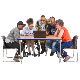 A group of people sitting around a table looking at a computer.