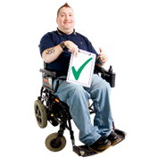 A person in a wheelchair holding a document with a tick.