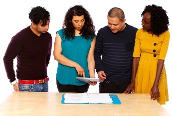 A group of people looking at an iPad together.