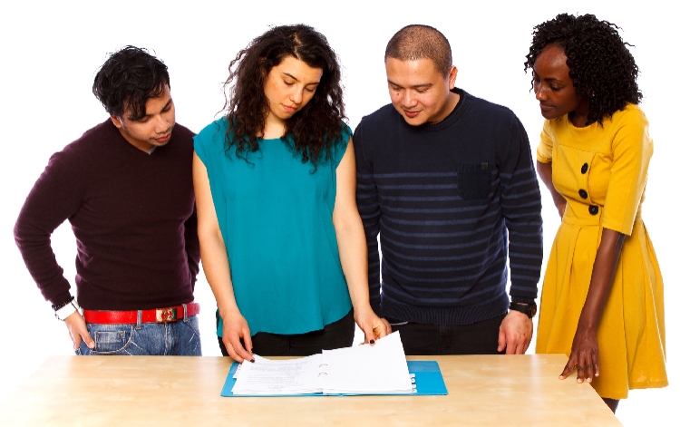 A group of people looking at a document together. 