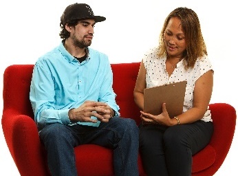 2 people sitting on a couch reading a document.