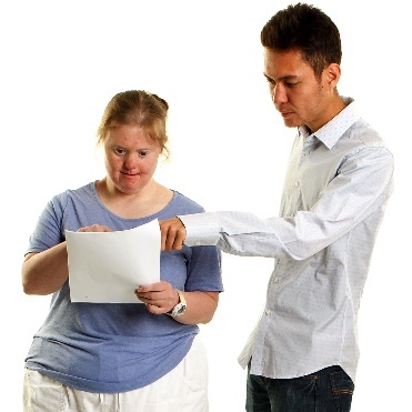 A person pointing at a document that a person with disability is holding.