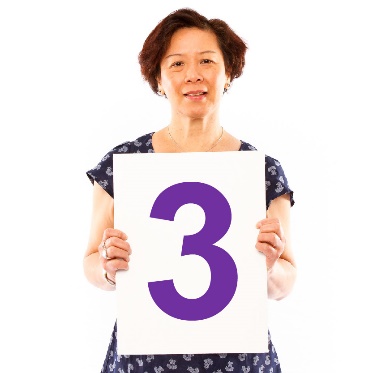 A person holding a sign with a '3' written on it.