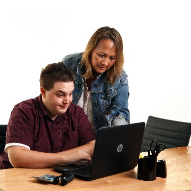 A person helping someone else use a computer.