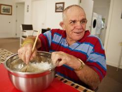 A person in a wheelchair mixing flour.