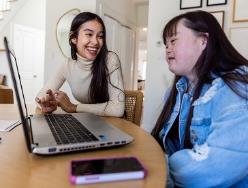 Two people working on a laptop together.