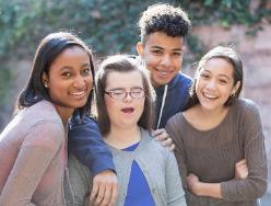 A photo of a group of people. One of them has a visible disability. 